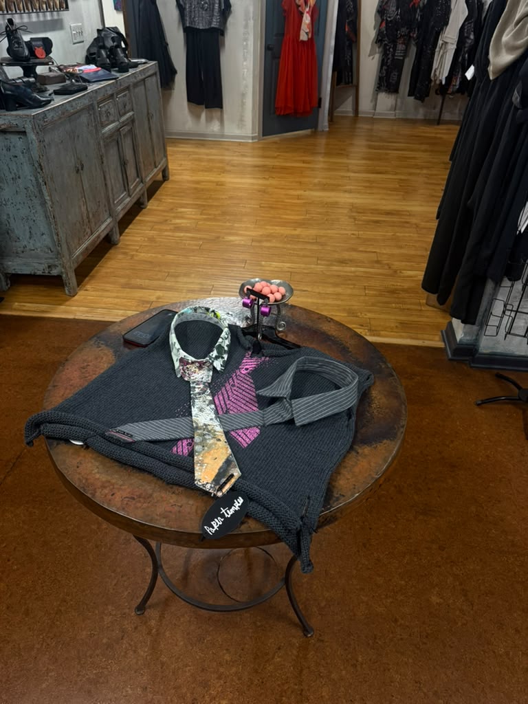 A knit and a painted tie laid out on the table at Gaia